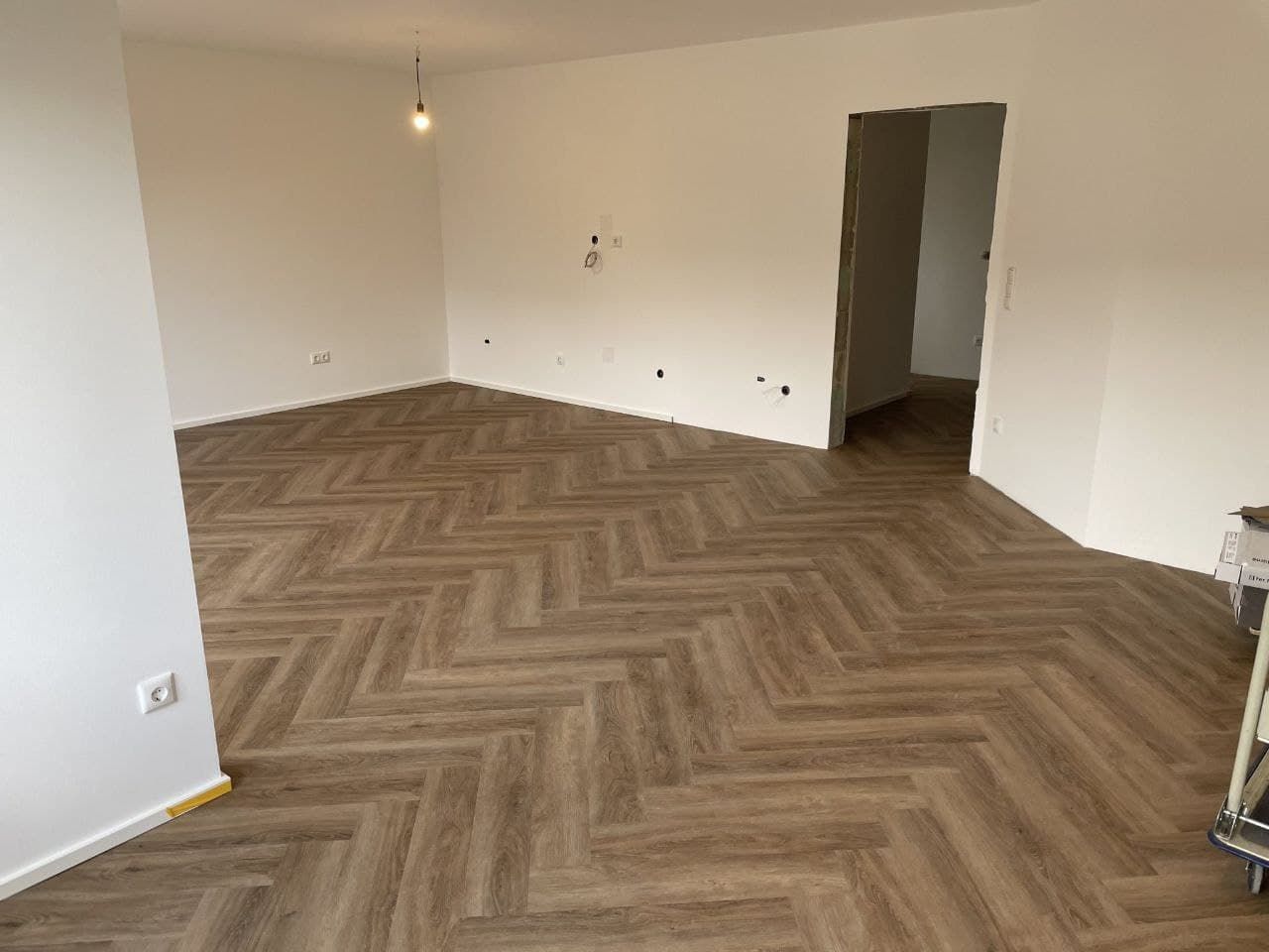 Leeres Zimmer mit weiß gestrichenen Wänden und Decke, das Streiflicht zeigt einen geraden Deckenanschluss.